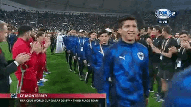 a group of soccer players are walking on a field with a fox sports logo on the bottom