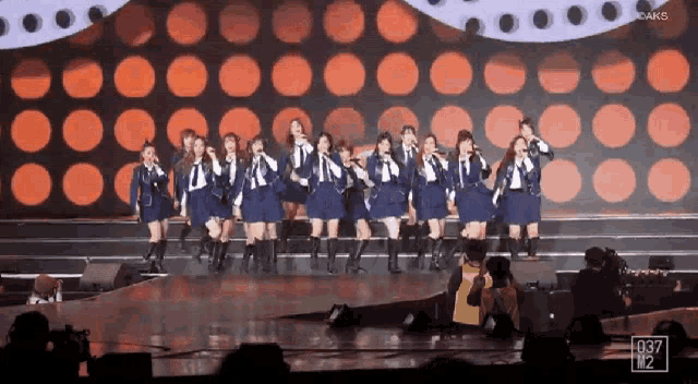 a group of women singing on a stage with the number 1037 on the bottom right