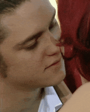 a close up of a man kissing a woman on the forehead