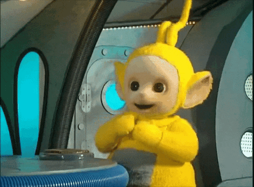 a yellow teletubbies doll is standing in front of a door