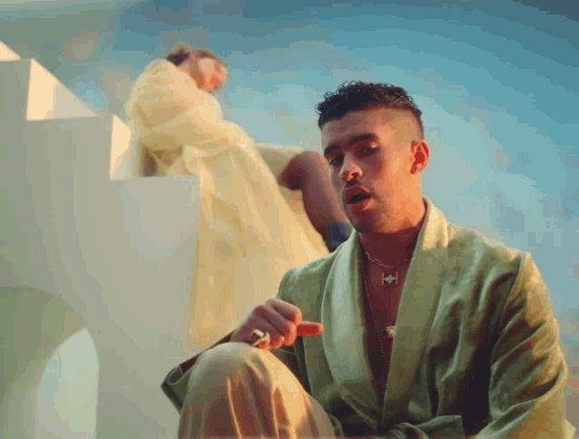 a man in a green robe is sitting in front of a woman in a yellow dress
