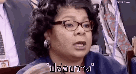 a woman wearing glasses and earrings is making a funny face in a foreign language .