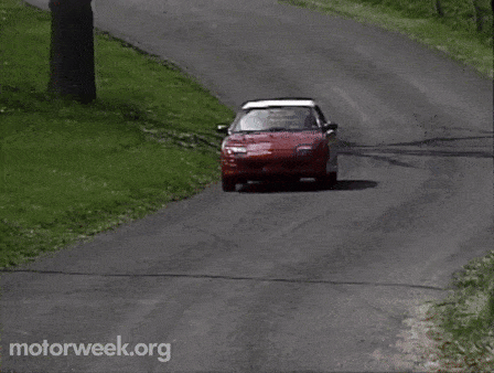 a red car is driving down a road with motorweek.org written on the bottom right