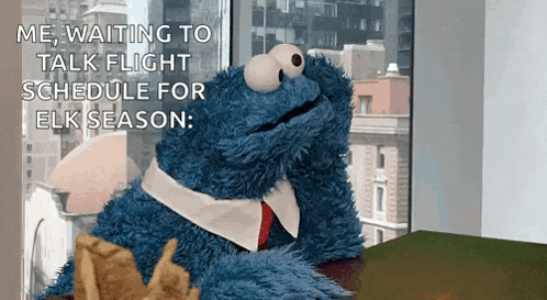 a cookie monster is sitting at a desk waiting to talk flight schedule for elk season ..