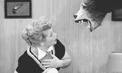 a black and white photo of a woman looking at a stuffed animal .