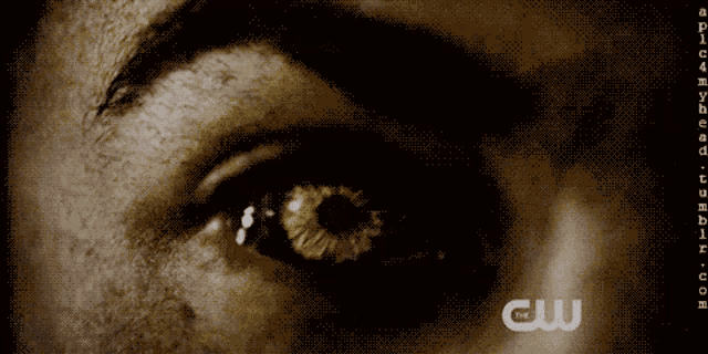 a close up of a person 's eye with the cw logo on the bottom