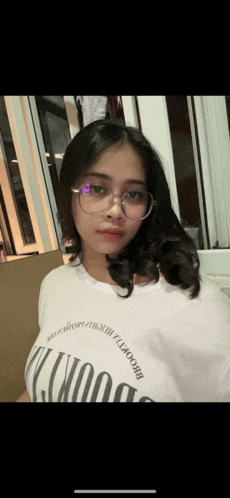 a girl wearing glasses and a white shirt that says brooklyn