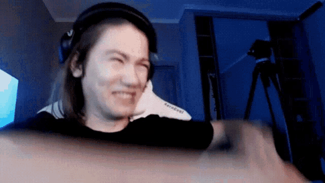 a woman wearing headphones is making a funny face while sitting in front of a camera .