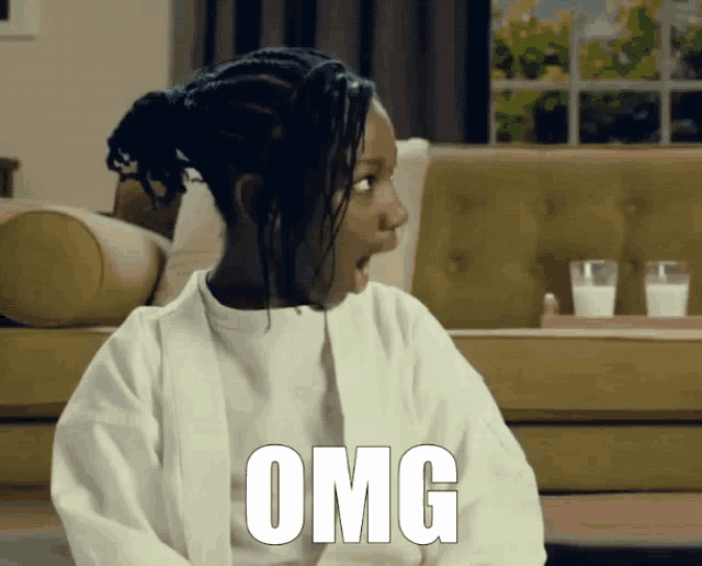 a girl is sitting on a couch with her mouth open and the word omg is above her head