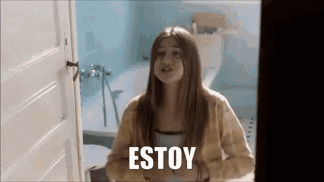 a woman is standing in a bathroom with the word estoy on her chest