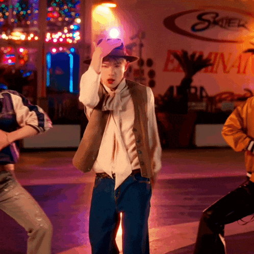 a man in a hat is dancing in front of a sign that says skiena