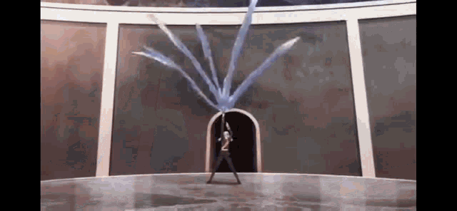 a person is standing in a room with a sword in their hand and a bunch of water coming out of it .