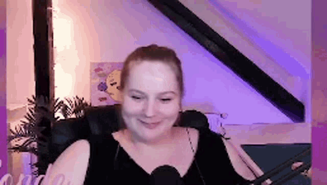 a woman is sitting in a chair with a microphone in front of her .