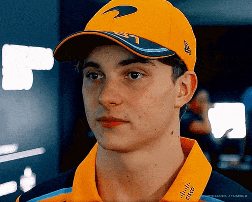 a young man wearing a hat and a cisco shirt