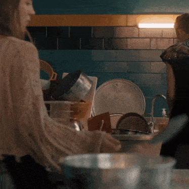 a woman is washing dishes in a kitchen with a bowl that says ' avocado ' on it