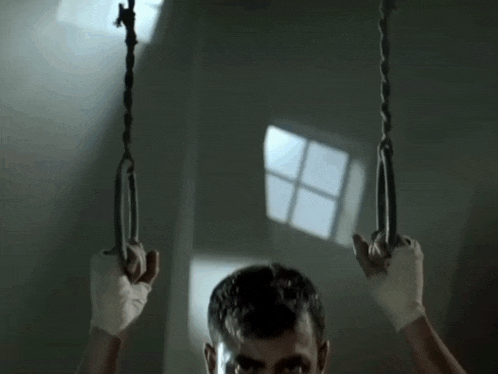 a man in a blue shirt is holding a pair of chains