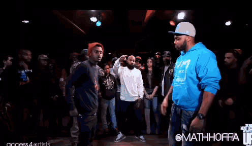 a man wearing a blue hoodie and a hat is screaming in a crowd ..