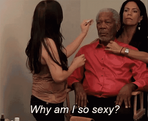 a woman is applying makeup to a man while another woman says why am i so sexy