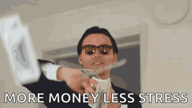 a man in a suit and sunglasses is holding a bunch of money and saying `` more money less stress '' .