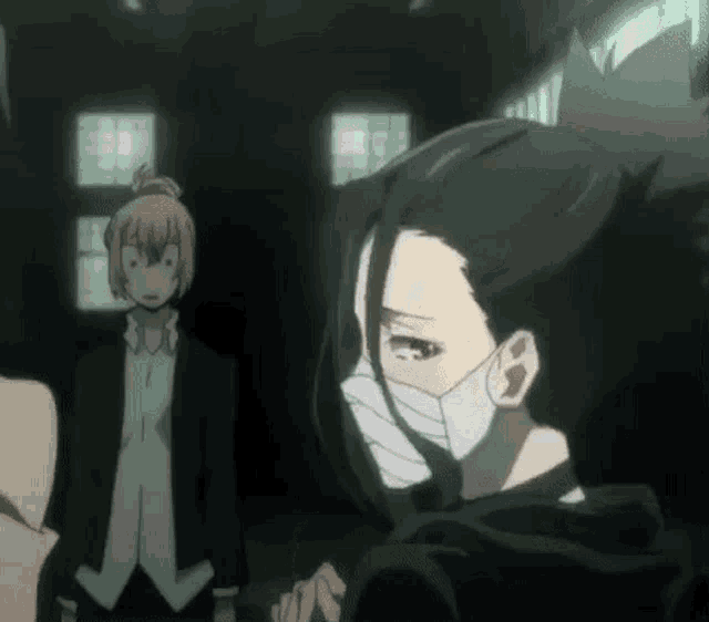 a woman wearing a mask is standing next to a man in a suit and tie .