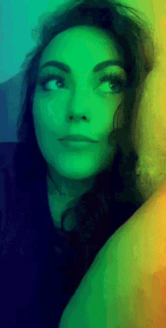 a woman with a rainbow colored background looks up