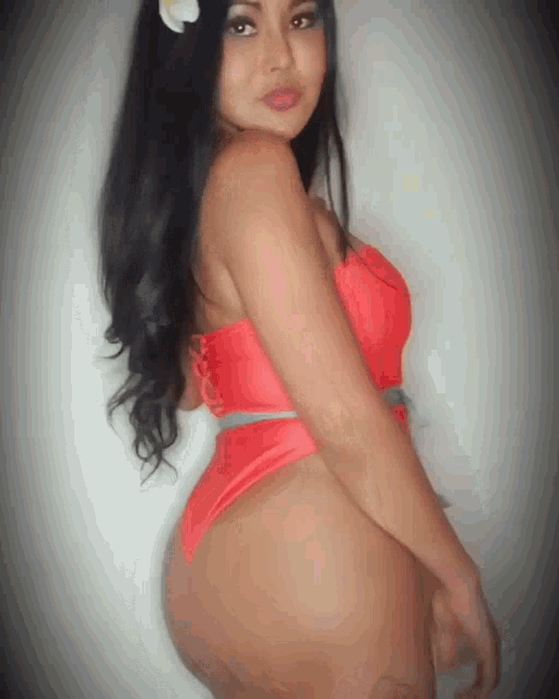 a woman wearing a red swimsuit with a flower in her hair