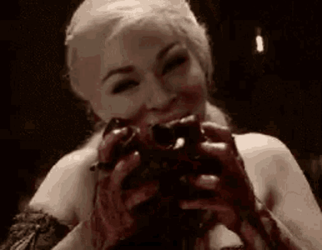a woman is holding a bloody apple in her hands and smiling .