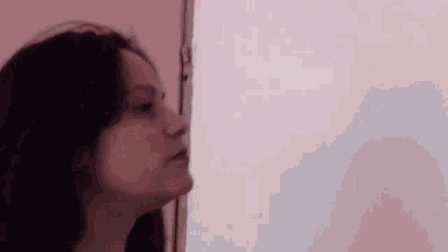 a woman is standing in front of a mirror looking at herself .