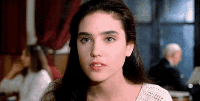 a close up of a woman 's face with a man in the background .