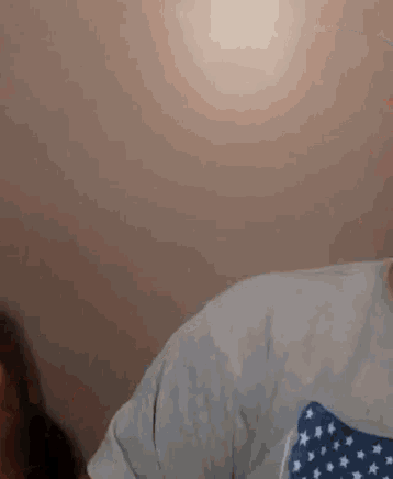 a man with a beard is wearing a white shirt with a blue and white american flag on it .