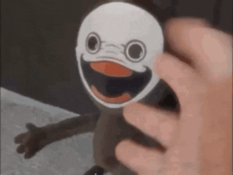 a person is putting a sticker on a toy that looks like a duck .