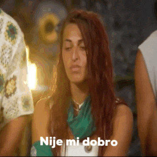 a woman with red hair is wearing a green scarf around her neck and says nije mi dobro .