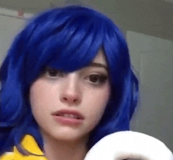 a close up of a woman wearing a blue wig and holding a white object .