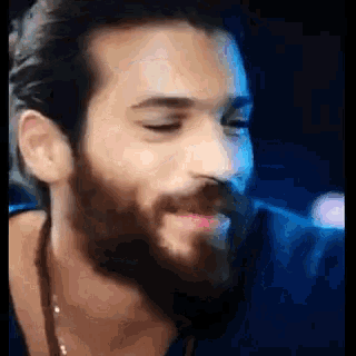 a close up of a man with a beard and long hair
