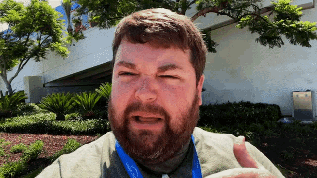 a man with a beard wears a lanyard that says disneyland on it
