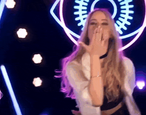a woman is blowing a kiss in front of a football logo