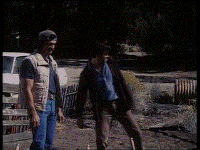 a man and a woman are standing next to each other in a field .