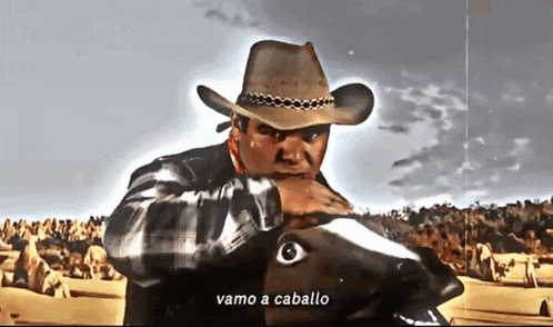 a man in a cowboy hat is holding a horse 's head and says vamos a cavallo