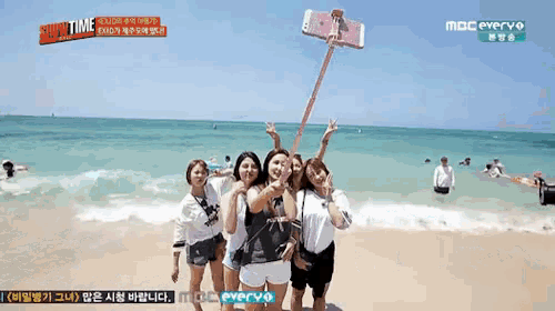 a group of women are posing for a picture on a beach with a mbc everyo logo in the corner