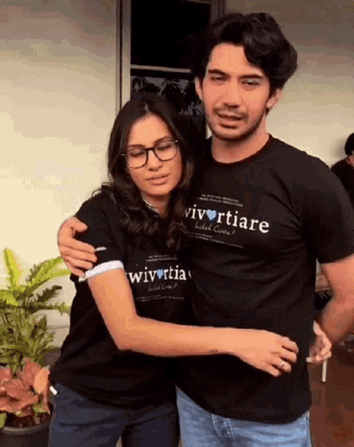 a man and a woman are hugging and the man is wearing a t-shirt that says vivertiare