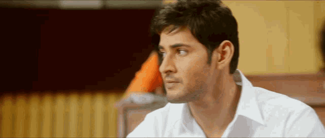 a man in a white shirt is looking to his left