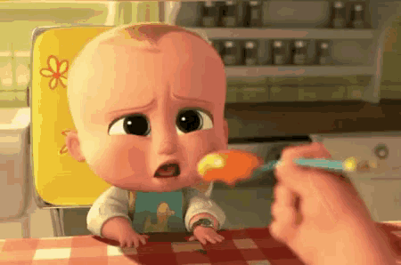a cartoon baby is being fed with a spoon by a person