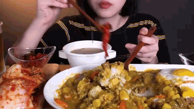a woman is eating food with chopsticks and a bowl of soup .