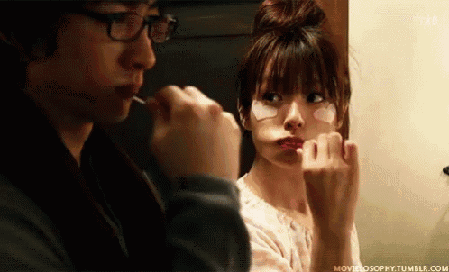 a man is brushing his teeth while a woman applies eye patches to her face
