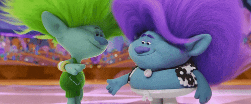two trolls with purple hair and green hair are hugging each other .
