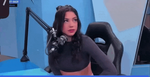 a woman is sitting in front of a microphone .