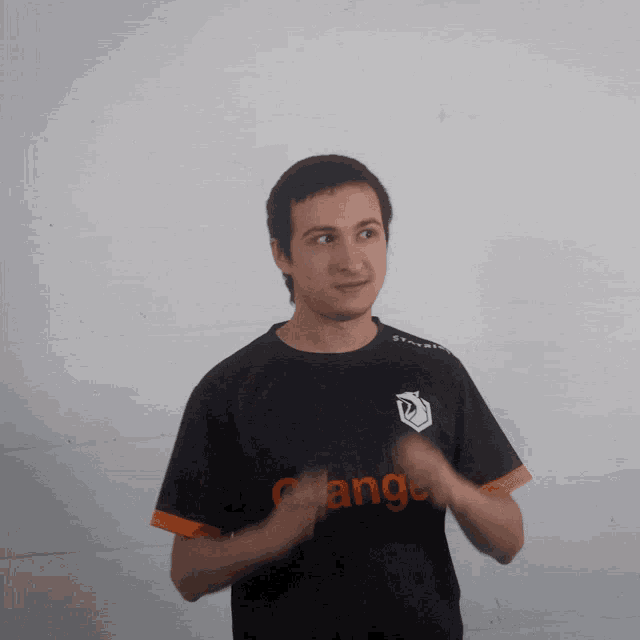 a man wearing an orange shirt is clapping