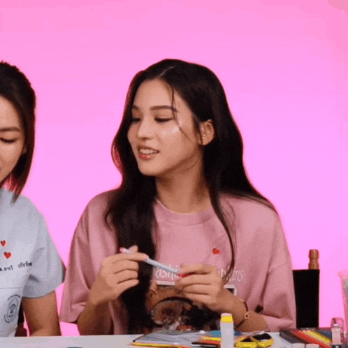 a girl wearing a pink shirt that says ' louis vuitton ' on the front