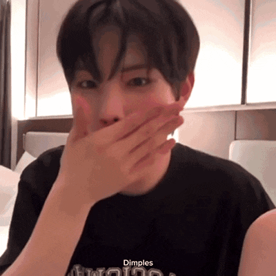 a young man wearing a black shirt that says dimples on it