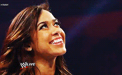 a woman is smiling in front of a wwe live logo